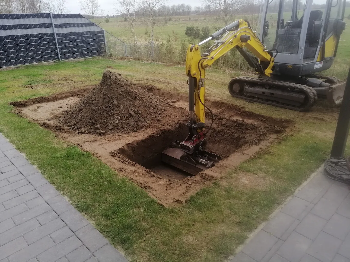 Minibagger bei Grabenarbeiten für eine Leitung