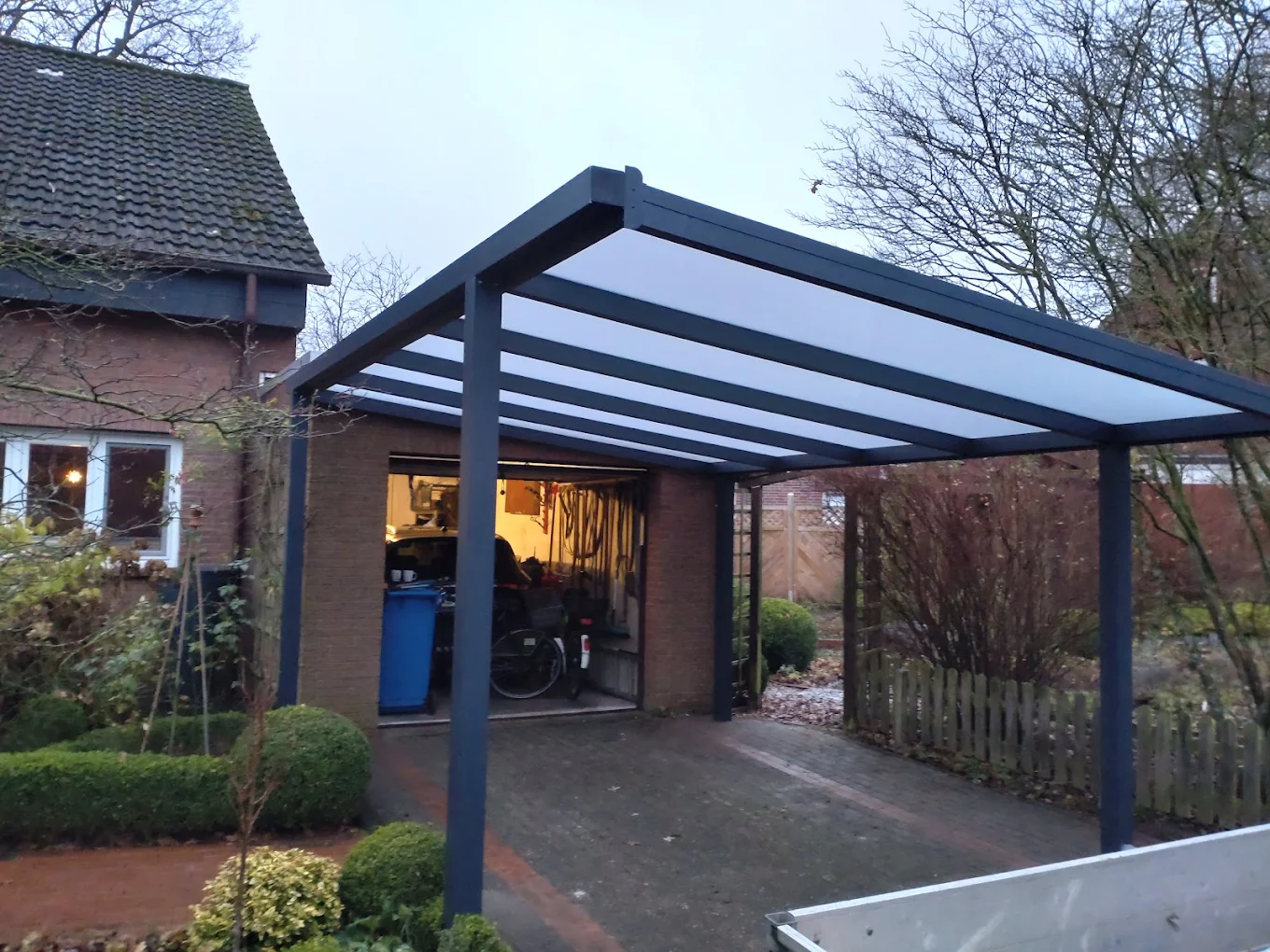 Carport in der Abenddämmerung an einem Wohnhaus