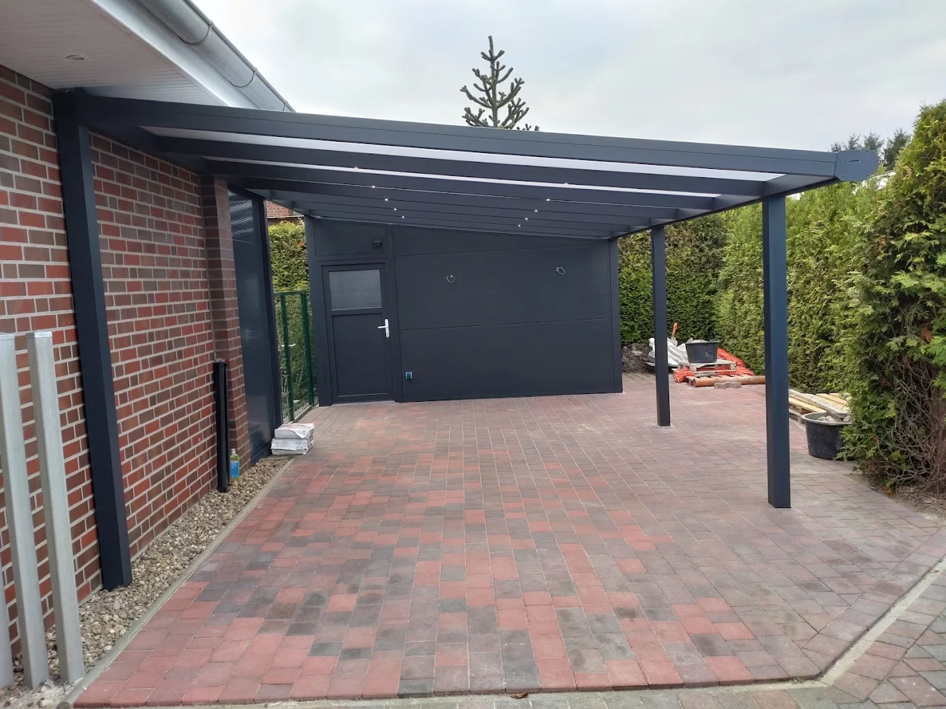 Carport mit angrenzendem anthrazitfarbenem Nebengebäude