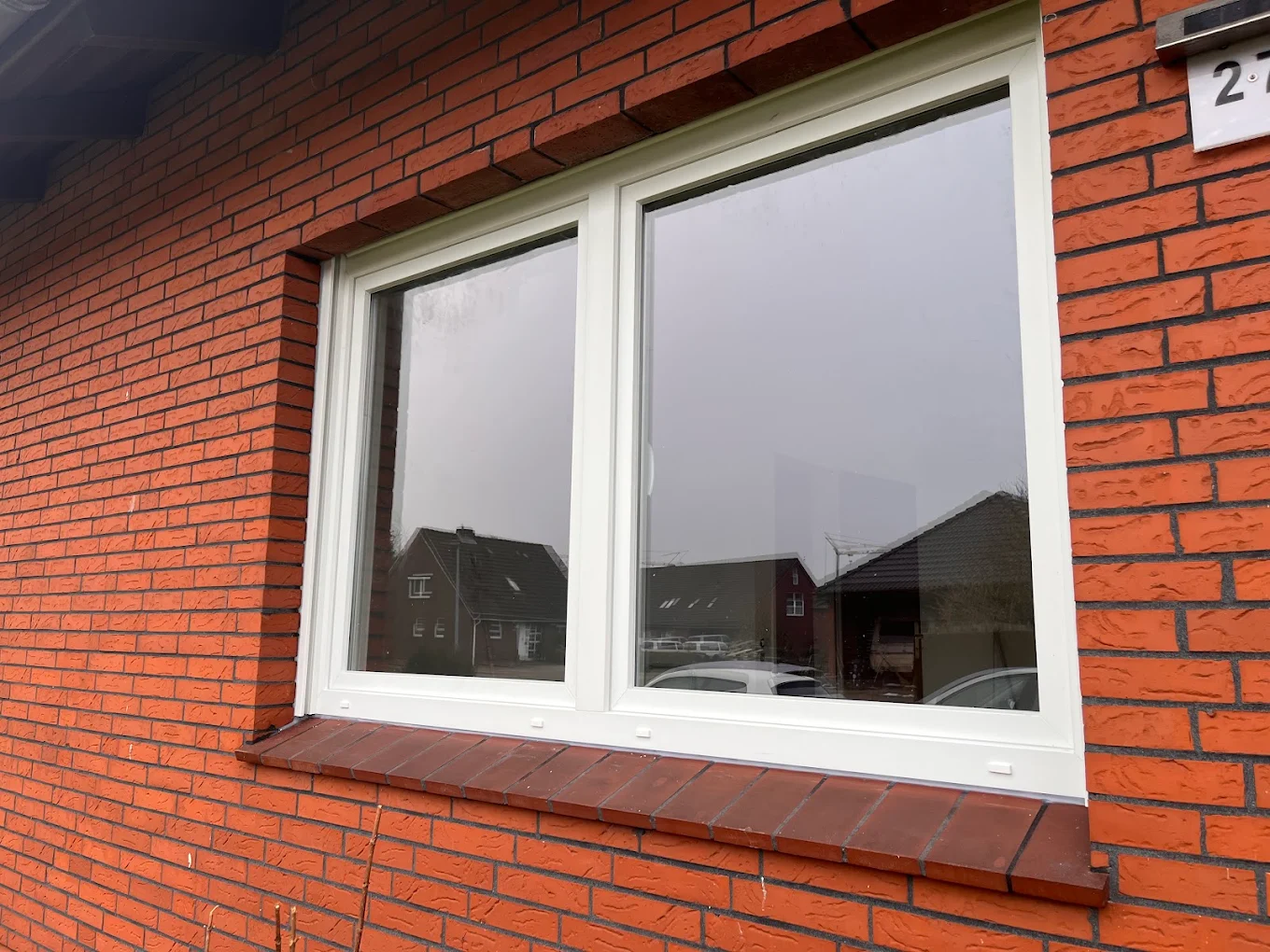 Kunststofffenster in Detailansicht an einer Backsteinfassade