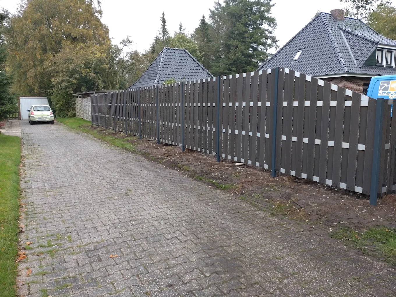 WPC-Sichtschutzzaun entlang einer Grundstückseinfahrt