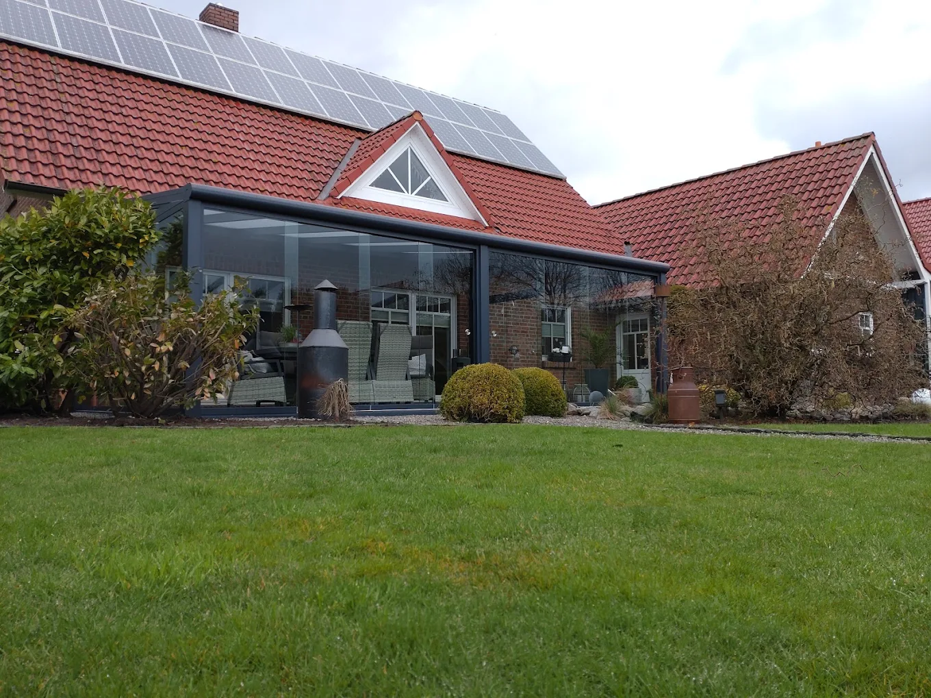Sommergarten an einem Backstein-Bauernhaus mit Solaranlage