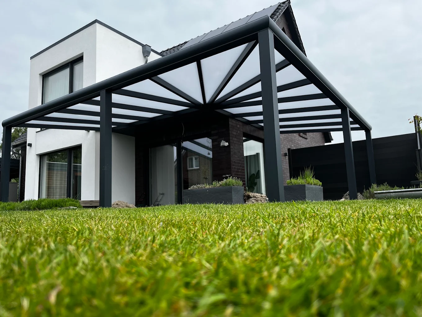 Terrassendach mit Walmdach an einem modernen weißen Haus